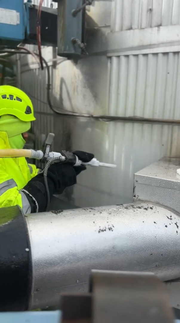 Industrial cleaning technician inspecting facility equipment