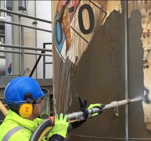 Worker using dustless blasting for metal restoration